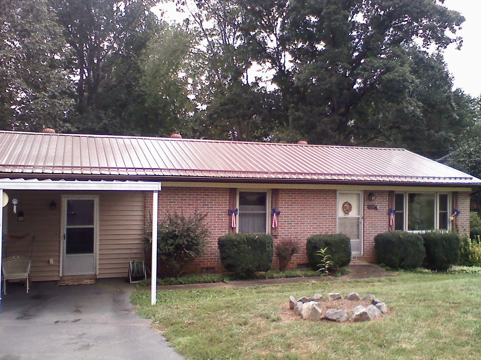 Bronze metal roof and carport on a brick ranch home — Roof Repair work by our crew in Hanson