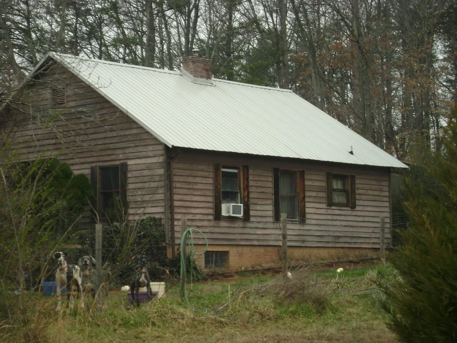White metal roof on an old wood sided farmhouse, from a Metal Roof Installation job in Hanson